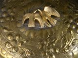 a gold box with a bird on it on a black surface