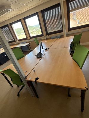 une longue table avec des chaises vertes dans un bureau