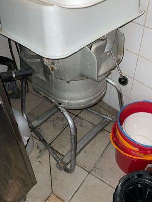 un lavabo blanc et un seau rouge dans une salle de bains
