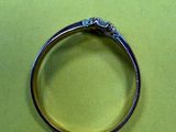 une bague en argent sertie d'un diamant, posée sur une surface verte