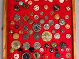 a picture of a display of buttons in a wooden frame