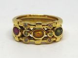 une image montrant un gros plan d'une bague en or sertie de pierres de différentes couleurs