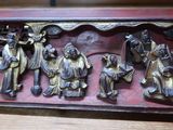 une photo d'une plaque en bois sur laquelle figure un groupe de personnes