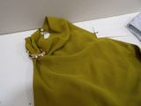 a green dress with a gold ring on it