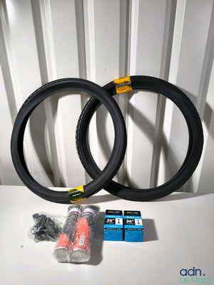 une paire de pneus de vélo noirs avec des jantes jaunes posés sur une table blanche