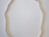 gros plan d'un collier de perles blanches sur une surface blanche