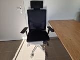 a black office chair sitting in front of a wooden desk