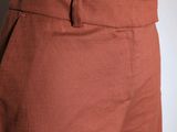 the back of a woman ' s pants with a white top and brown pants