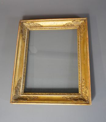 un cadre doré ancien avec un miroir accroché à un mur gris