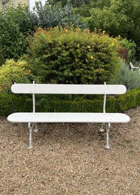 un banc blanc posé au milieu d'une aire de gravier