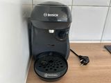 a black coffee maker sitting on a counter next to a wall