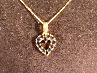 Chaîne en or et pendentif cœur orné de saphir.