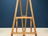 an image of a wooden easer stands against a blue wall