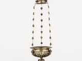 a brass hanging lamp with a bird on top of it