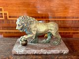 une statue de lion posée sur un socle en marbre