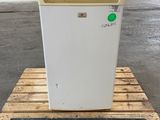 un réfrigérateur blanc posé sur une palette en bois