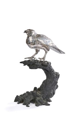 une statue représentant un oiseau perché sur une branche d'arbre