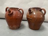 deux vases bruns posés l'un à côté de l'autre sur une table