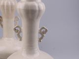 two white vases that are sitting on a table