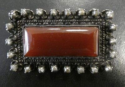 an image of a picture of a red stone in a silver frame