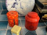 many different tins sitting on the floor next to each other