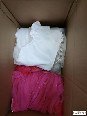 une boîte en carton remplie de vêtements et d'une couverture rose