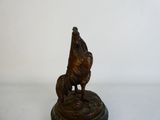 statue en bronze représentant un chien et un coq, posée sur un socle en marbre
