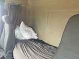 a bed in the back of a van with a red suitcase