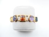 a close up of a gold ring with multi colored stones