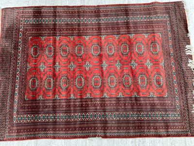 a close up of a red rug on a white surface