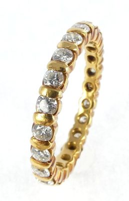 a close up of a gold and diamond ring on a white surface
