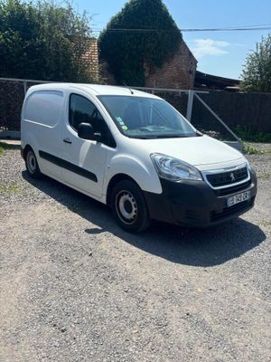 La camionnette blanche est garée sur le chemin de gravier devant une maison.