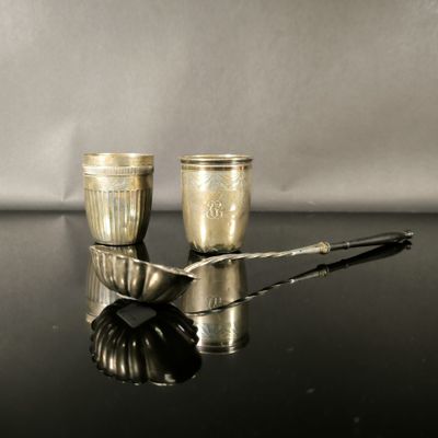 deux tasses et cuillères en argent posées sur une table noire