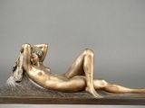 statue of a woman laying down on a table with her legs crossed