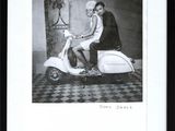 black and white photograph of a woman sitting on a motor scooter