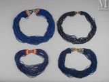 un lot de quatre colliers bleus avec des fermoirs dorés