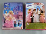 two barbie dolls are sitting next to each other on a table