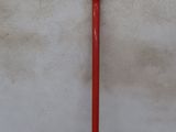 an image of a red shovel leaning against a white wall