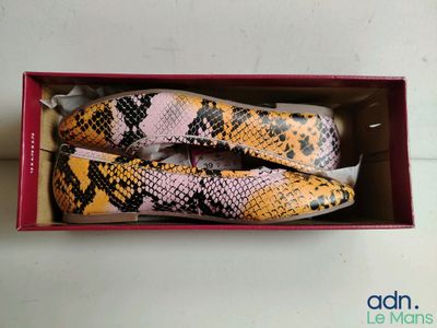 deux paires de chaussures en peau de serpent dans une boîte posée sur une table