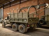 a large army truck parked in a building with other military vehicles