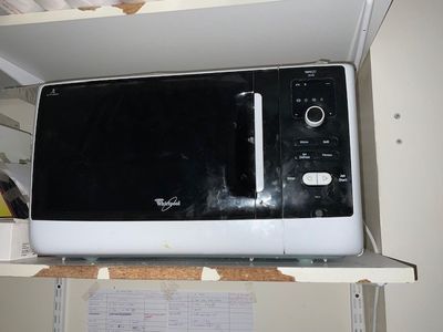a microwave sitting on top of a shelf in a kitchen