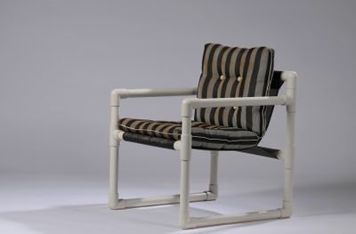 a white chair with a striped seat and a black and white striped cushion