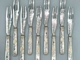 cinq fourchettes et six couteaux sur une table