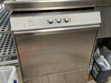 stainless steel dishwasher in a commercial kitchen next to a sink