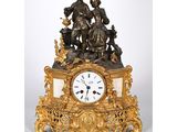une horloge en or sur laquelle figurent un homme et une femme