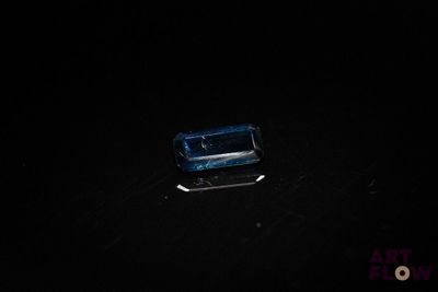 an image of a blue glass object on a black surface