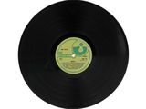 a black vinyl record with a green and white label on it