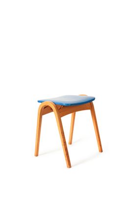 un petit tabouret en bois avec une assise bleue sur fond blanc