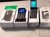 Plusieurs téléphones portables sont posés sur une table, à côté de boîtes qui en contiennent d'autres.