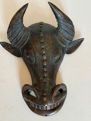 une tête de taureau en métal avec des cornes, accrochée au mur